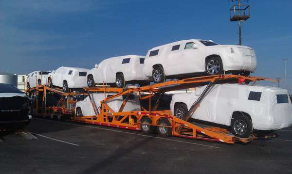 Full-size utility vehicles are covered and loaded on a carrier to test the new covers that will be used for exports from General Motors&acirc; Arlington, Texas, Assembly Plant.