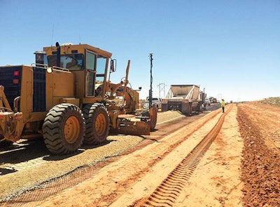 On Arizona’s U.S. 89T emergency bypass construction in 2013, aggregate base is spread over triaxial geogrid above a graded base. The use of geogrid cut one-third of the cost of the aggregate base.