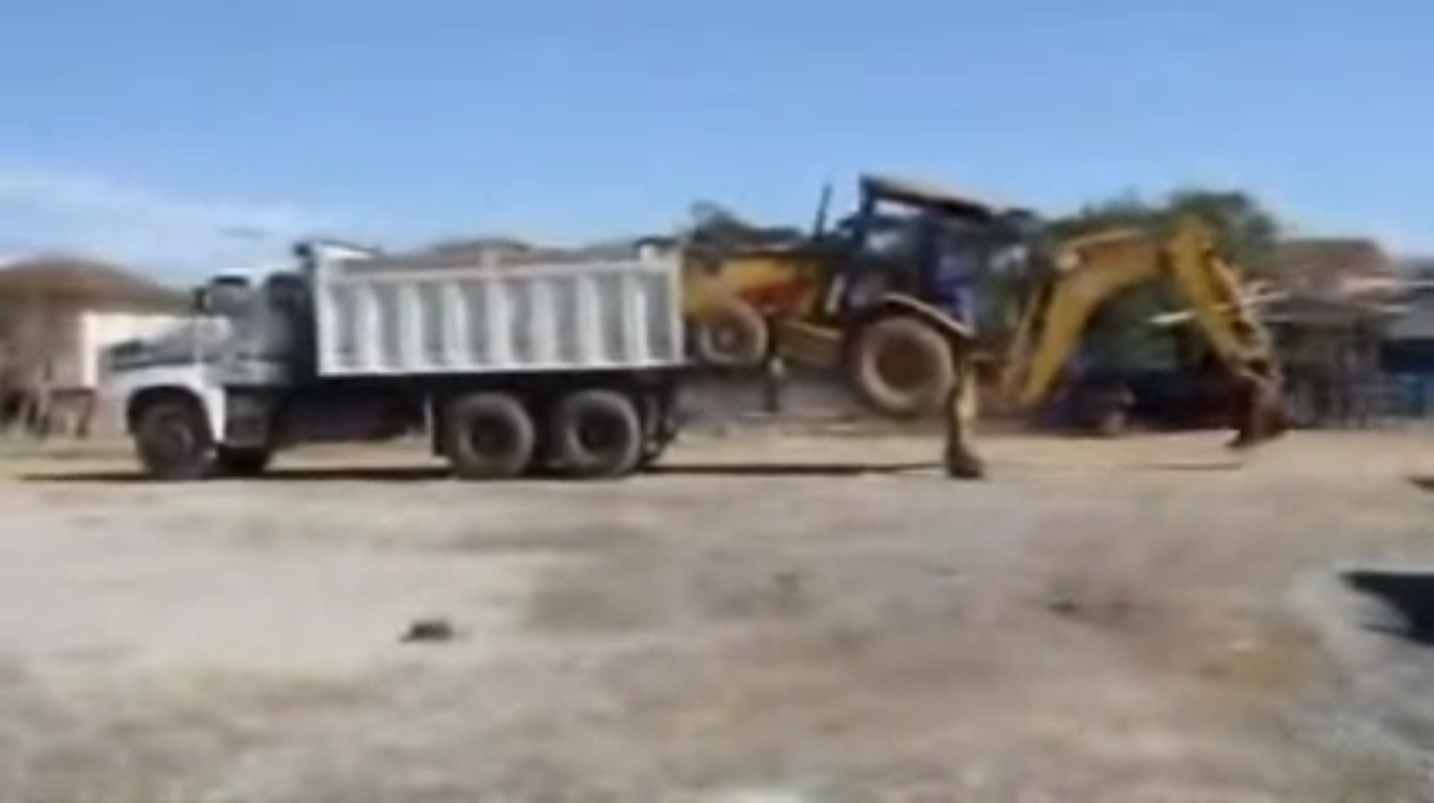 Backhoe loaded into a dump truck