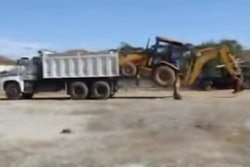 Backhoe loaded into a dump truck