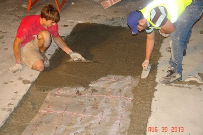 Students at the University of Wisconsin-Milwaukee install a slab of a new waterproof concrete atop data-gathering sensors. Credit: UWM
