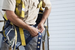 Worker putting on safety harness