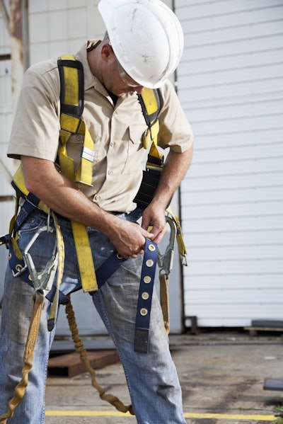 Worker putting on safety harness
