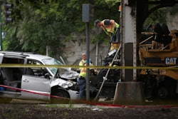 A crew works to dislodge a minivan from a paver after a crash in Chicago Saturday morning that killed one construction worker. Credit: Abel Uribe/Chicago Tribune