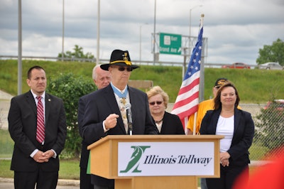 Allen J. Lynch speaks during the ceremony. Behind him, from left to right, are: Illinois Department of Veterans’ Affairs Assistant Director Rodrigo Garcia, State Sen. Terry Link, former State Rep. JoAnn Osmond and Illinois Tollway Executive Director Kristi Lafleur.