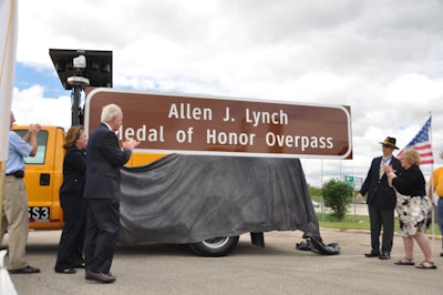 (from left to right) Illinois Tollway Executive Director Kristi Lafleur, State Sen. Terry Link, Allen J. Lynch and former State Rep. JoAnn Osmond applaud after overpass sign is unveiled.