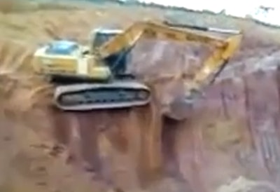 Excavator topples off bench