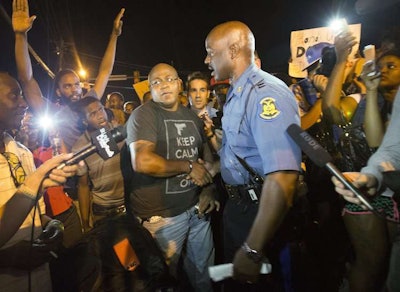 Missouri Highway Patrol Captain and newly appointed head of security in Ferguson Ron Johnson speaks with protesters. Credit: Mario Anzuoni/Reuters