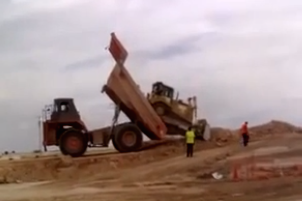 Mining truck dumps a bulldozer