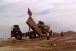 Mining truck dumps a bulldozer