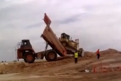 Mining truck dumps a bulldozer