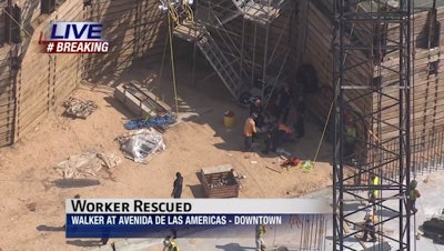 A stretcher basket is lowered into a pit as fire crews attend to a construction worker after he suffered a heart attack. Credit: KTRK TV Houston