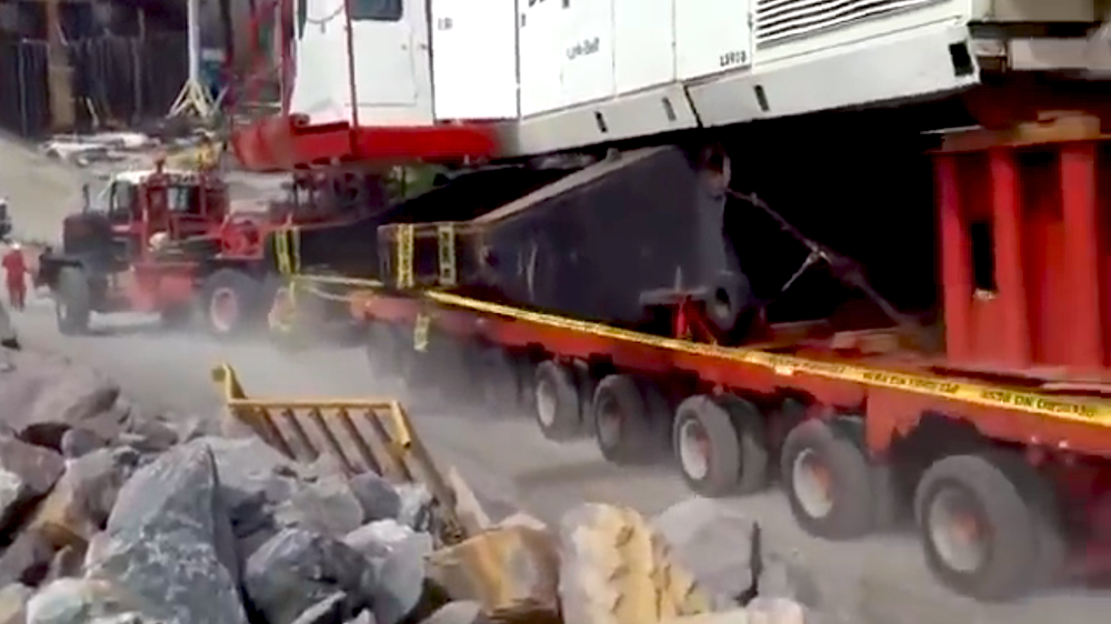 crane shoves truck down hill