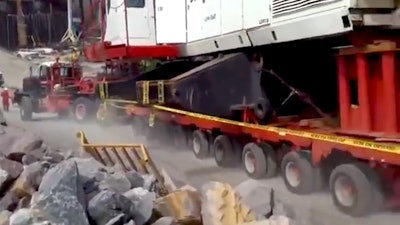 crane shoves truck down hill