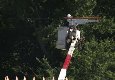 An electric co-op worker examines the power line above a home construction site where a construction worker was killed. Credit: CBS 6 TV
