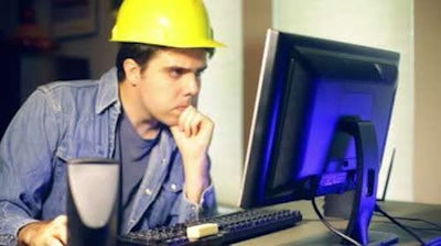 Construction worker looking at computer monitor