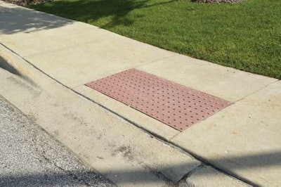 Pictured is a regulation curb on a suburban street. An important part of this requirement is the obligation that whenever street, roadways or highways are altered, curb ramps be provided where street level pedestrian walkways cross curbs.