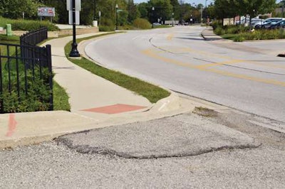 Where the Sidewalk Ends: Makeshift asphalt ramp serves until surface or friction course of asphalt is placed in condo development.