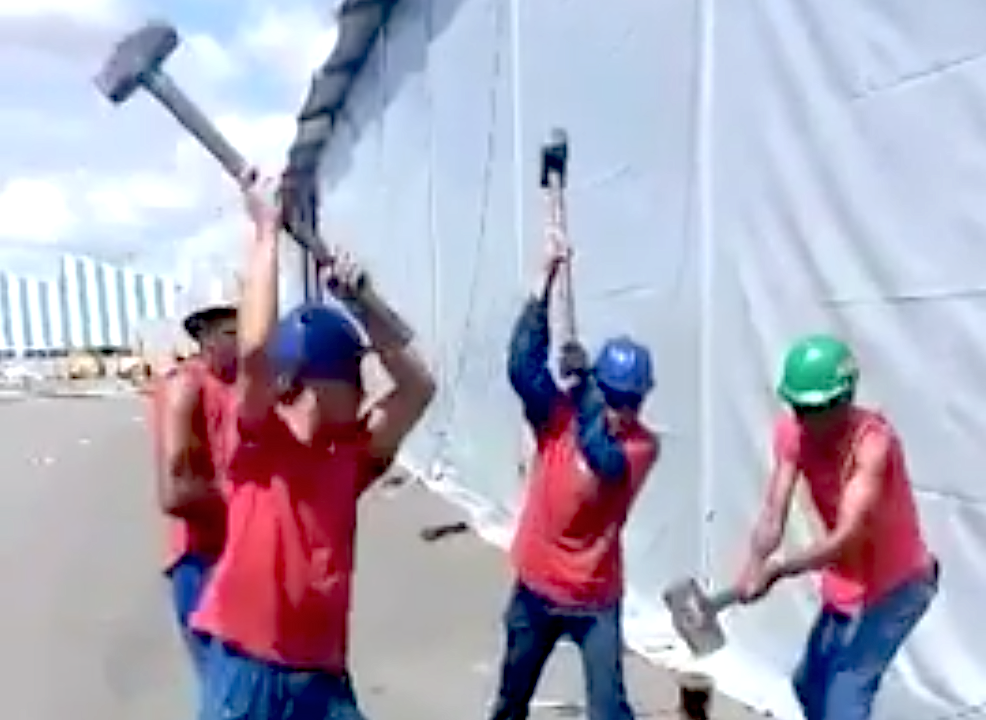 Workers sledgehammering stake
