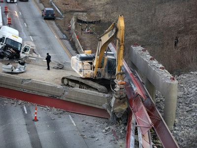 Beams rest atop an excavator following a pancake collapse of an overpass being prepared for demolition in Cincinnati. Credit: Liz Dufour/Cincinnati Enquirer