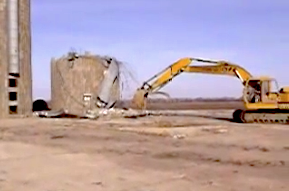 Excavator yanks down silo