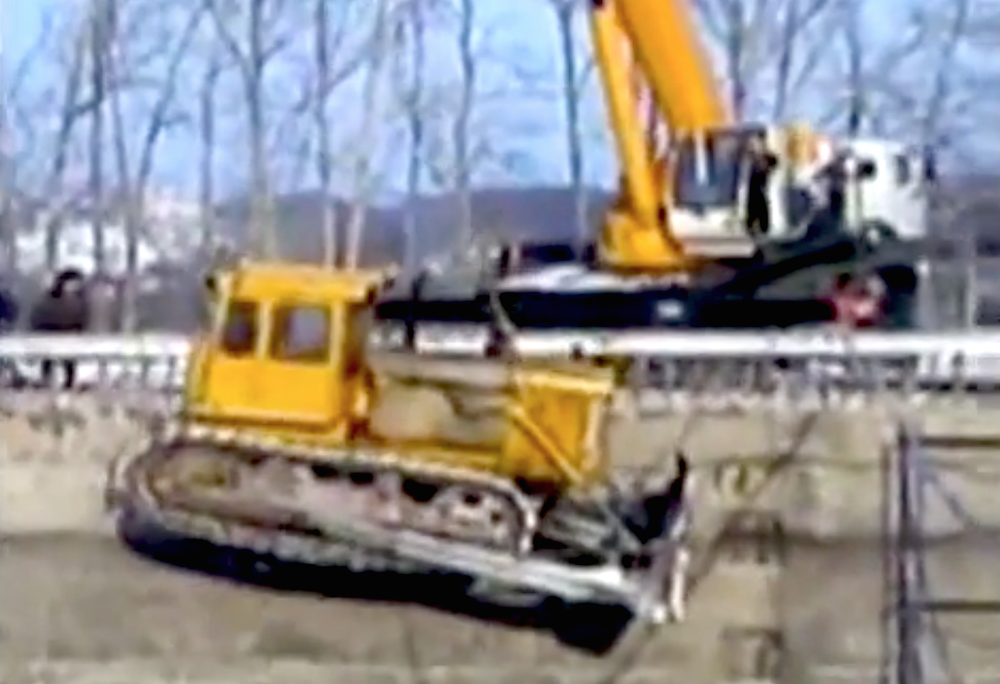 Crane drops dozer
