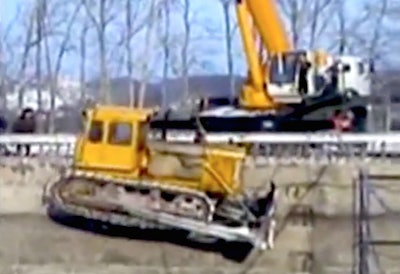 Crane drops dozer