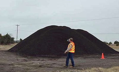 A worker measures a stockpile with the Stockpile Reports iPhone app.