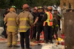 In this still from KENS 5 video, firefighters can be seen gathering near the trench the worker was rescued from.