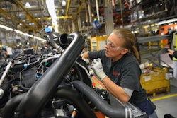 Ford worker fitting cooling system on 2015 F-150 as it moves down assembly line in the Kansas City plant.