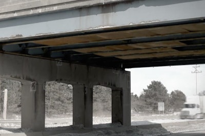 An image of a bridge with visible plywood barriers from the Safe Roads Yes! campaign supporting a rise in the Michigan sales tax for highway funding.