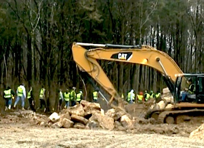 In this still from WHAS video, soil and rock is sifted and carefully monitored while volunteer workers search through the surrounding woods for clues to the skull’s origin.
