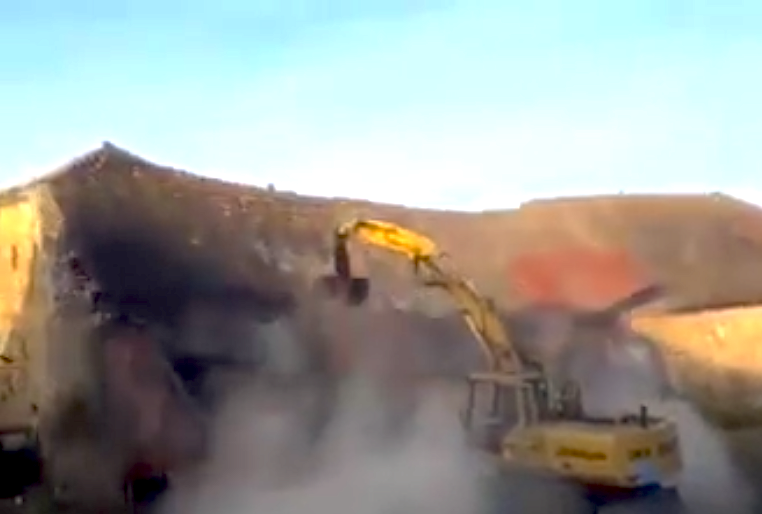 Excavator shoves barn
