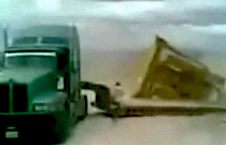 Semi jackknifes while towing dozer