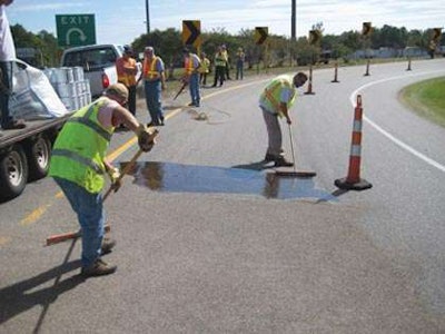 A crew performs a high friction surface treatment. Credit: FHWA