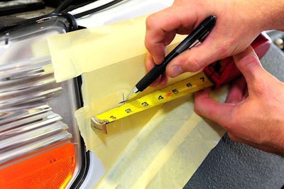 Put down masking tape to hold mark and to keep the drill bit from chipping paint.