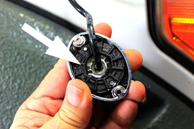 Snap plastic retaining ring (arrow) to chrome bezel to hold LED lighthead.