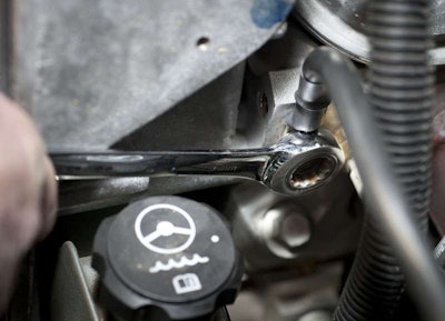The main ground cable from the auxiliary battery should connect to the engine block. A good location is the open threaded hole just below the alternator bracket.