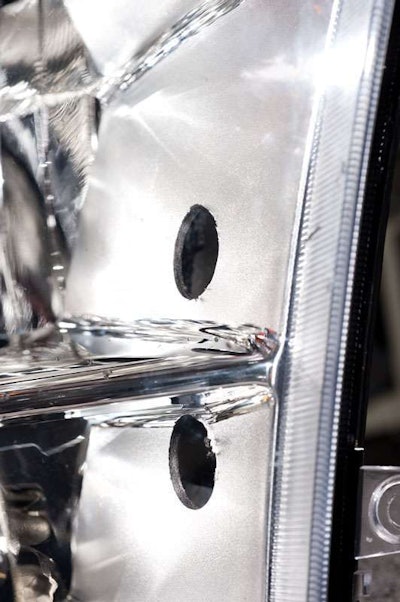 Each mounting hole is close to the center of the upper and lower headlight reflectors.