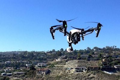 A drone on hire from the new DroneBase service, hovers during a residential job.