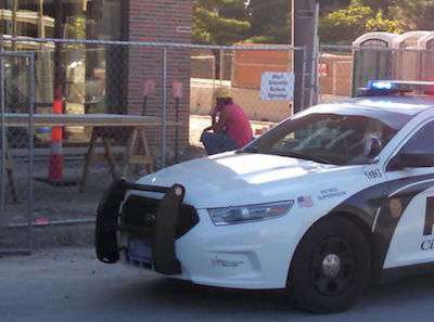A worker sits following a scaffolding fall that took the life of two co-workers on an Ames jobsite June 19. Photo Credit: Matthew Rezab/Iowa State Daily