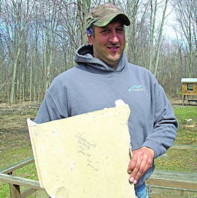 Herzog holds the piece of drywall his father signed more than 50 years ago. Credit: Bill Diller/Huron Daily Tribune