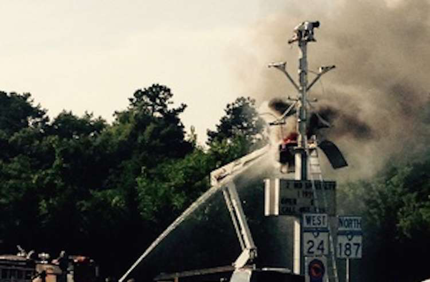 Bucket Truck Catches Fire Forcing Worker To Perch Atop Sign Until