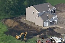 The scene of the trench collapse is seen in a still from WCCO TV footage.