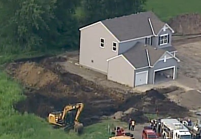 The scene of the trench collapse is seen in a still from WCCO TV footage.
