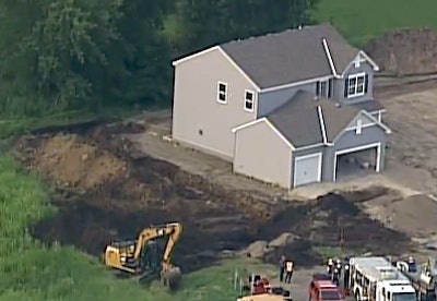 The scene of the trench collapse is seen in a still from WCCO TV footage.