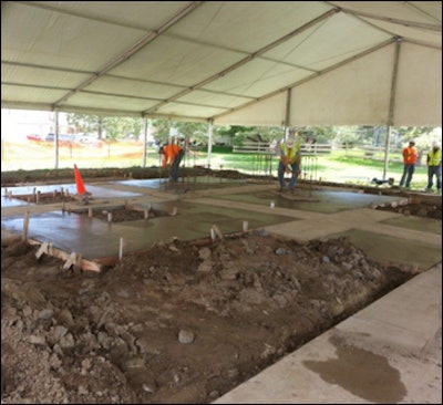 Volunteers formed and placed 1,000 square feet of textured concrete and colored exposed bands. The finish is a combination of a light tan colored concrete with two slightly darker bands running through the slab in a cross design.