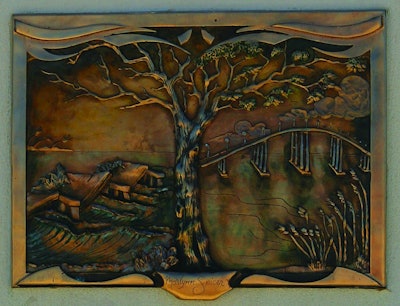 One of the relief plaques, made of bronze salvaged from bearing plates from the old bridges.