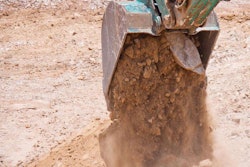 excavator bucket dumping dirt