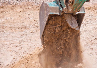 excavator bucket dumping dirt